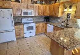 Main level kitchen with quartz counter top and stainless steel farmhouse sink (1 of 2 kitchens)