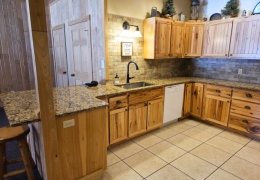 Lower level kitchen with quartz countertop and farmhouse sink