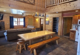 Open concept living room & kitchen space with an 8 ft log table