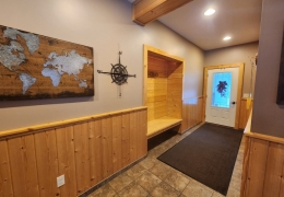 Entry door and hallway with built in bench and coat rack area